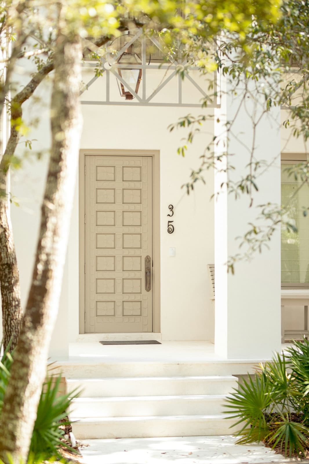A distinctive residential entry door framed by a bright coastal facade