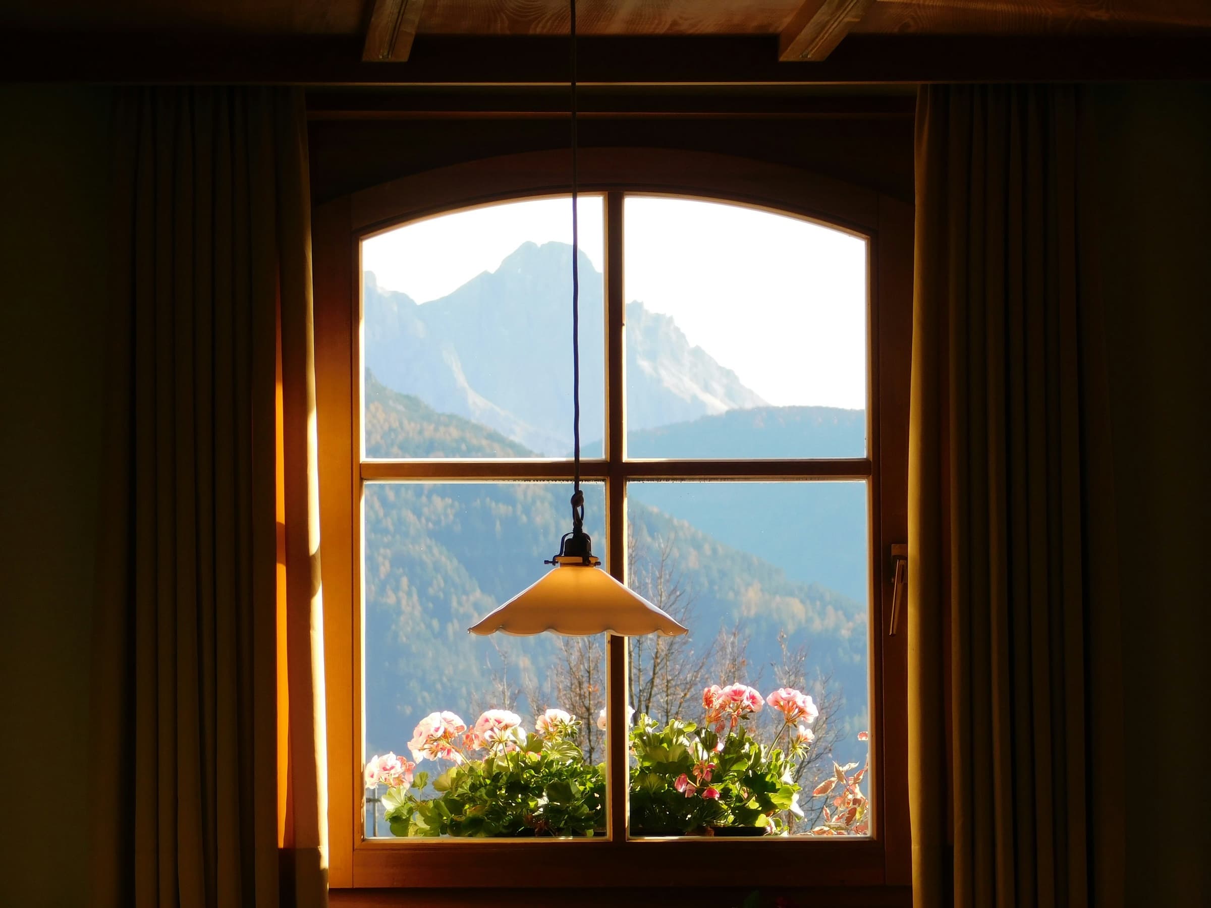 Warm interior window framing a mountain view